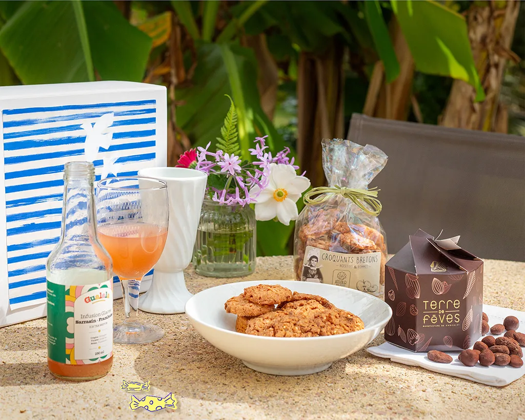 Panier gourmand breton été avec croquants, chocolats et infusion glacée, présenté en extérieur